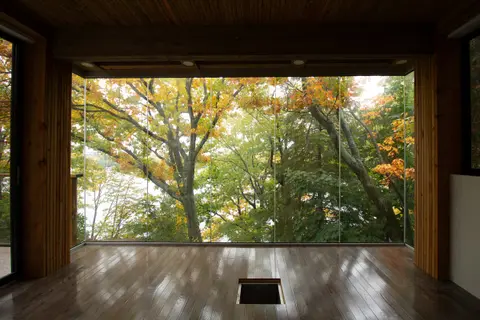 Solarium framed in timber, open on three sides to autumn maple trees