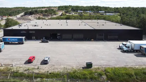 Aerial view of the large single-storey industrial building with trucks at the loading doors