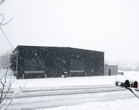 The re-clad building in falling snow