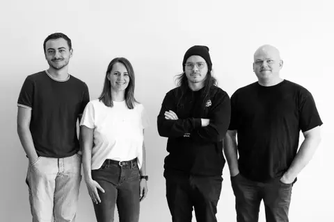 The DAO team standing against a white wall: Jason Presse, Katherine Morawietz, Jeremy Upward and Patrick Danielson